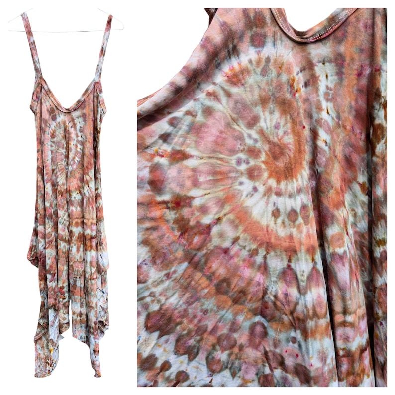 Op de afbeelding: Een mouwloze jurk met een spiraalvormig tie-dye patroon in tinten terracotta, oudroze, bruin en cr&egrave;me. Het kledingstuk heeft een diepe ronde halslijn, dunne schouderbandjes en een asymmetrische zoom met meerdere overlappende panelen.