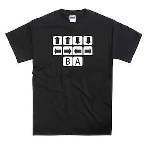 May include: Black t-shirt with a white graphic of a video game controller's directional buttons and the letters "BA".