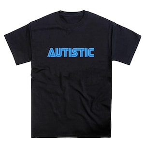 May include: Black t-shirt with the word "AUTISTIC" printed in light blue, retro-style font across the chest. The shirt has a crew neck and short sleeves. The text is centered on the shirt.