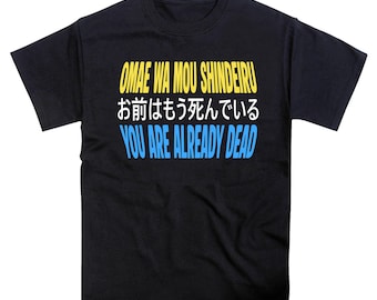 May include: A black short-sleeved t-shirt featuring three lines of text. The top line reads OMAE WA MOU SHINDEIRU in yellow, the middle line is Japanese text in white, and the bottom line reads YOU ARE ALREADY DEAD in light blue.