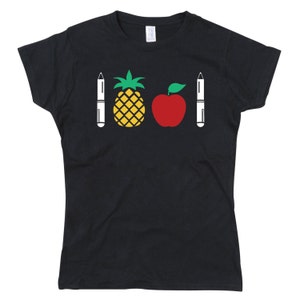 Op de afbeelding: Zwart T-shirt met een ananas, een appel en twee witte pennen bedrukt op de voorkant.