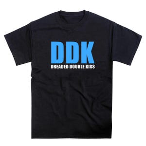 May include: Black crew neck t-shirt with the blue text "DDK" above the words "DREADED DOUBLE KISS" in white. The shirt is made of a soft material and is suitable for casual wear.