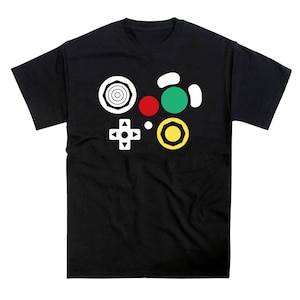 Könnte beinhalten: Schwarzes T-Shirt mit einer weißen Grafik eines Videospiel-Controllers. Der Controller besteht aus verschiedenen farbigen Kreisen und einem weißen Pluszeichen.