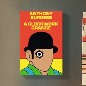 Op de afbeelding: Twee koelkastmagneten. De eerste magneet is rood en geel en heeft een zwart-witte illustratie van een personage uit het boek "A Clockwork Orange" van Anthony Burgess. De tweede magneet is wit en heeft een stapel boeken met een kind dat eroverheen kijkt. De tekst op de magneet luidt "So Many Books, So Little Time" en "Enoch Pratt Free Library".