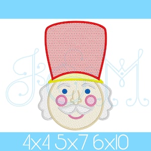 以下が含まれることがあります： 赤い帽子、黄色の縁取り、白いひげを生やしたナッツクラッカーの刺繍デザイン。ナッツクラッカーは青い目、ピンクの頬、口ひげをしています。デザインは、4x4、5x7、6x10インチなど、さまざまなサイズでご利用いただけます。