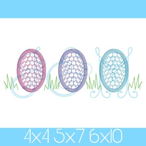 May include: Three embroidered Easter eggs in pink, purple, and blue with a white background. The eggs are surrounded by green grass.