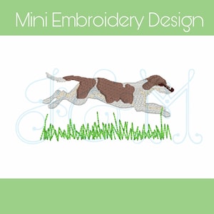 Puede incluir: Diseño bordado de un perro marrón y blanco corriendo por la hierba verde. El perro está en una pose de salto con la lengua fuera.