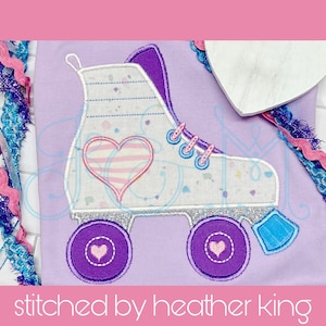 May include: Purple and white embroidered roller skate with a pink and white striped heart on the side. The roller skate has a blue and white wheel and a blue and white stopper.