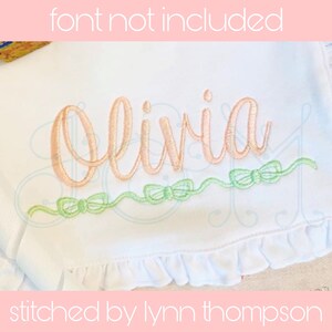 Könnte beinhalten: Weißer Stoff mit dem Namen "Olivia" in pfirsichfarbenem Garn gestickt. Unter dem Namen befindet sich eine Reihe grüner Schleifen. Der Text "font not included" und "stitched by lynn thompson" sind ebenfalls vorhanden.
