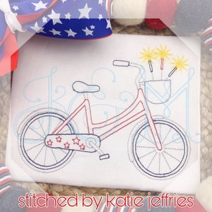 May include: Red and blue bicycle with a basket filled with yellow fireworks. The bicycle has a white background with a blue and red star pattern on the back tire.