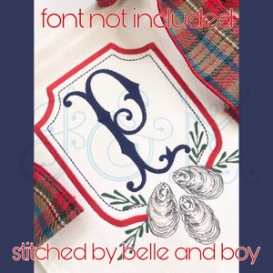 May include: Embroidered design on a white fabric featuring a navy blue letter "P" within a red-outlined shield. The design includes green sprigs and three oyster shell illustrations. The text "font not included" and "stitched by belle and boy" are also visible.