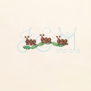 May include: Three brown snails with green leaves embroidered on a white background.