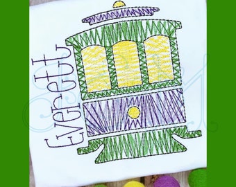 May include: Embroidered design of a green, yellow, and purple streetcar with the name "Everett" stitched in purple on a white t-shirt. The text "stitched by the little stitchery" is at the bottom of the image.
