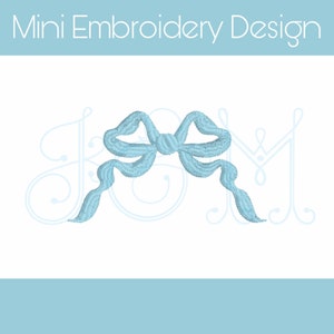 Puede incluir: Un diseño de lazo bordado en azul claro sobre fondo blanco. El texto "Mini Embroidery Design" está en la parte superior. El lazo presenta costuras detalladas y cintas fluidas. Adecuado para proyectos de bordado y manualidades.