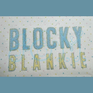 Puede incluir: Una tela blanca con letras bordadas en azul y amarillo que deletrean "Blocky Blankie".