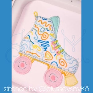 May include: A colorful embroidered patch of a roller skate with a blue, yellow, and orange abstract pattern. The skate has pink wheels with white stitching.