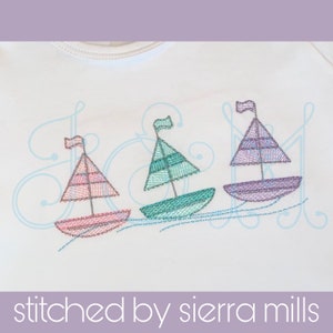 May include: Three embroidered sailboats in pink, green, and purple, with white accents, are stitched on a white fabric. The sailboats are sailing on a blue wavy line.