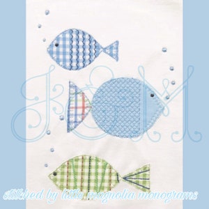 May include: Three embroidered fish on a white background. The fish are blue, green, and blue and white gingham. The fish are stitched with a decorative stitch. The text "stitched by little magnolia monograms" is at the bottom of the image.