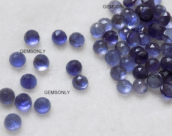 May include: A collection of 20 faceted, round, blue gemstones. The gemstones are approximately 6mm in diameter and have a variety of shades of blue.