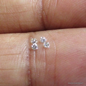 May include: Three small, round, clear diamonds on a finger.
