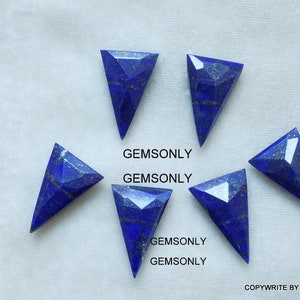 May include: Six triangular shaped lapis lazuli gemstones with a dark blue color and gold flecks. The gemstones are arranged in a semi-circle on a white surface.