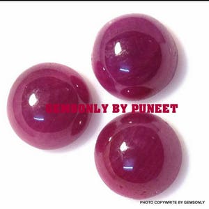 May include: Three round, polished ruby gemstones. The gemstones are a deep red color and have a glossy finish.
