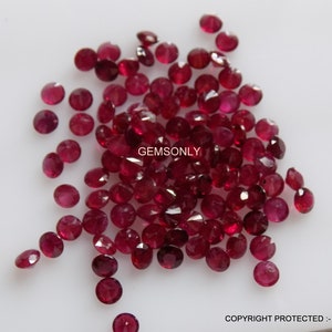 May include: A pile of loose red ruby gemstones, each with a round, faceted shape. The gemstones are arranged in a loose pile on a white surface. The image is labeled "GEMSONLY".