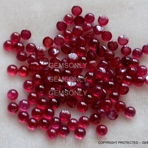Op de afbeelding: Een grote groep ronde, rode robijn edelstenen. De edelstenen zijn ongeveer 4 mm in diameter en hebben een gladde, gepolijste afwerking.