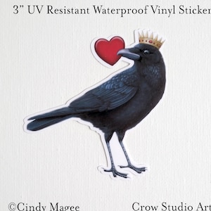 May include: A 3" UV resistant waterproof vinyl sticker featuring a black crow wearing a gold crown and holding a red heart. The sticker is titled "Crow Studio Arts".