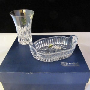 May include: A clear glass serving dish with two handles and a matching clear glass drinking glass. Both pieces are in a blue box with the word "Waterford" printed on the bottom.