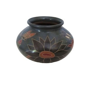 May include: A rounded black ceramic pot featuring a wide opening and a smooth finish. The exterior is decorated with hand-painted floral motifs in shades of red and orange, accented by delicate butterfly illustrations in red and blue tones.