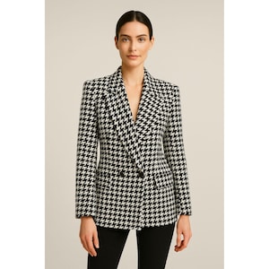 May include: A black and white houndstooth blazer with a double-breasted design. The jacket features a notched lapel and a classic pattern. The blazer is a stylish piece of outerwear.