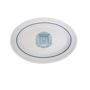 May include: Oval white serving platter with a blue border and a central emblem. The emblem features a building facade with the text "MARK TWAIN MANOR" in a circular arrangement. The platter has a decorative rim.