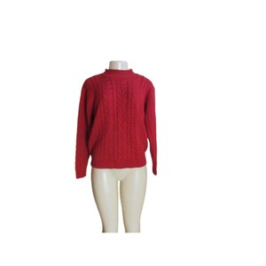 May include: A red cable knit sweater with a mock neck.