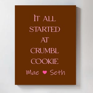 a brown poster with the text "It all started at Crumble Cookie" written in pink.