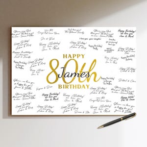May include: A personalised 80th birthday sign with gold lettering reading "Happy 80th James Birthday." The sign is designed for guests to sign, with numerous handwritten messages and a pen included.