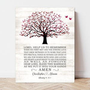 May include: A framed print with a tree design and text. The tree has a black trunk and branches with red leaves. The text includes a prayer and names, Christopher & Alaina, with a date, February 14, 2022, on a white wood-grain background.
