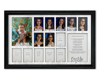 May include: A white wooden picture frame with black trim holds a collage of photos of a girl growing up. The photos are arranged in a grid pattern, with the girl's age listed below each photo. The frame also includes a quote about children learning what they live. The girl's name, Sophia, is written in large letters at the bottom of the frame.