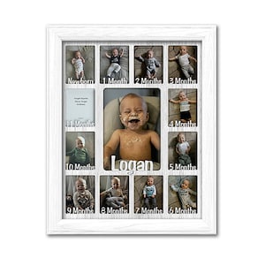 May include: A white wooden picture frame with 12 openings for photos. The frame is designed to hold photos of a baby at different ages, from newborn to 11 months. The frame has the name "Logan" written on it.