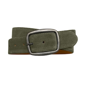 May include: An olive green suede belt featuring a rectangular, brushed metal buckle with a rounded frame. The belt strap has visible stitching along the edges and multiple punched holes for adjustment, showcasing a textured finish and a tan underside.