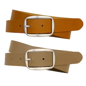 Pode incluir: Dois cintos com tiras de couro liso e fivelas de metal arredondadas em tom prateado. O cinto superior é de cor castanho claro, enquanto o cinto inferior tem um tom taupe suave. Ambos os cintos apresentam uma série de orifícios perfurados.