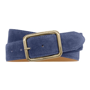 Op de afbeelding: Een blauwe suède riem met een rechthoekige, goudkleurige metalen gesp. De riem heeft een zachte, matte textuur en is afgewerkt met een gladde, beige voering aan de binnenzijde, met zichtbare stiksels langs de randen van de riem.