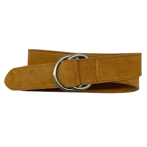 May include: A tan suede belt with a double O-ring buckle. The belt is a warm brown color and appears to be made of soft suede material. The silver-colored buckle is a prominent feature.