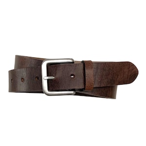 Puede incluir: Un cinturón de cuero marrón con una hebilla plateada. El cinturón está enrollado y la hebilla está en el centro de la imagen.