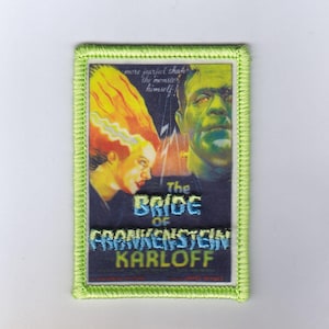 Könnte beinhalten: Gestickter Aufnäher mit grünem Rand, der ein Vintage-Filmplakat für "Frankensteins Braut" mit Karloff zeigt. Der Aufnäher zeigt die Braut mit gelbem Haar und Frankensteins Monster. Der Text lautet "The Bride of Frankenstein Karloff".