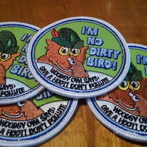 May include: Four green and white embroidered patches with a cartoon owl wearing a green hat and the text "I'm No Dirty Bird!" and "Woodsy Owl Says: Give a Hoot! Don't Pollute."