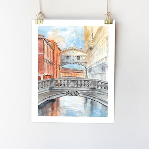 May include: Watercolor painting of a bridge in Venice, Italy. The bridge is arched and has a stone railing. The water below the bridge is a light blue color. The buildings on either side of the bridge are a light orange color.