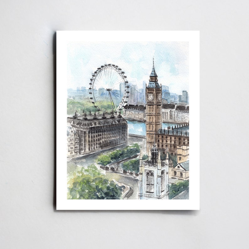 May include: Watercolor print of London landmarks, including the London Eye, Big Ben, and Westminster Abbey. The artwork features a high-angle view with soft blues, greens, and browns, capturing the city's architecture and the Thames River.