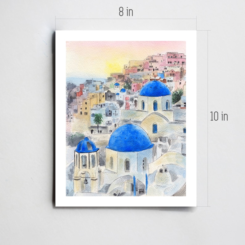 May include: Watercolor painting of a white building with blue domed roofs in a village setting. The building is surrounded by other white buildings with pink and yellow accents. The sky is a soft pink and yellow.