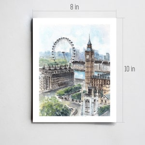 May include: Watercolor print of London landmarks, including the London Eye and Big Ben. The artwork is 8 inches wide and 10 inches tall. The print features a soft color palette of blues, greens, and browns, capturing a scenic cityscape.
